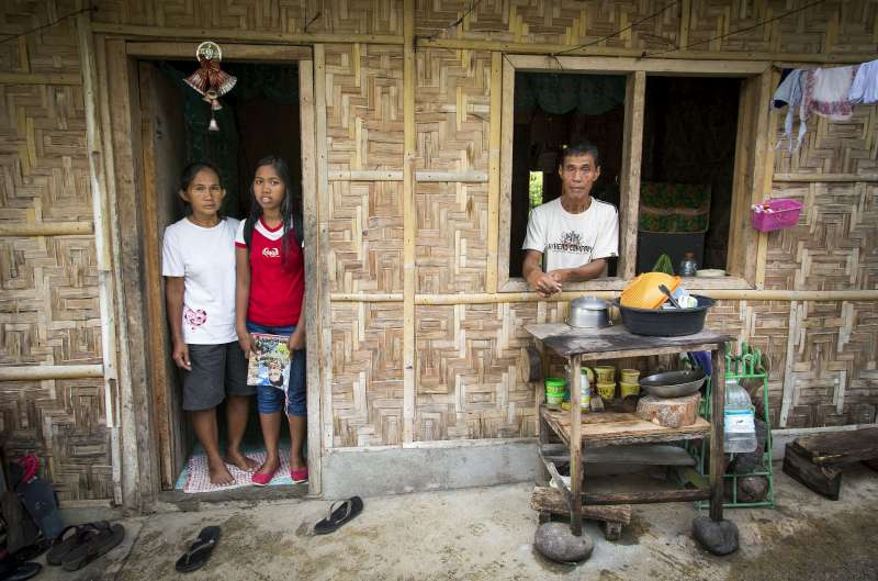 Merlyn Mandak (left) at home in Kidapawan with her youngest daughter, Mary Che, and husband Joseph. They are among more than 6,000 people of Indonesian descent in the southern Philippines.