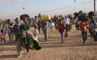 Syrian Kurds with their belongings after crossing into Turkey's Sanliurfa province at the weekend.