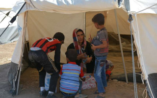Sahla and three of her boys in their UNHCR tent at the Ministry of Agriculture site in Erbil, northern Iraq.