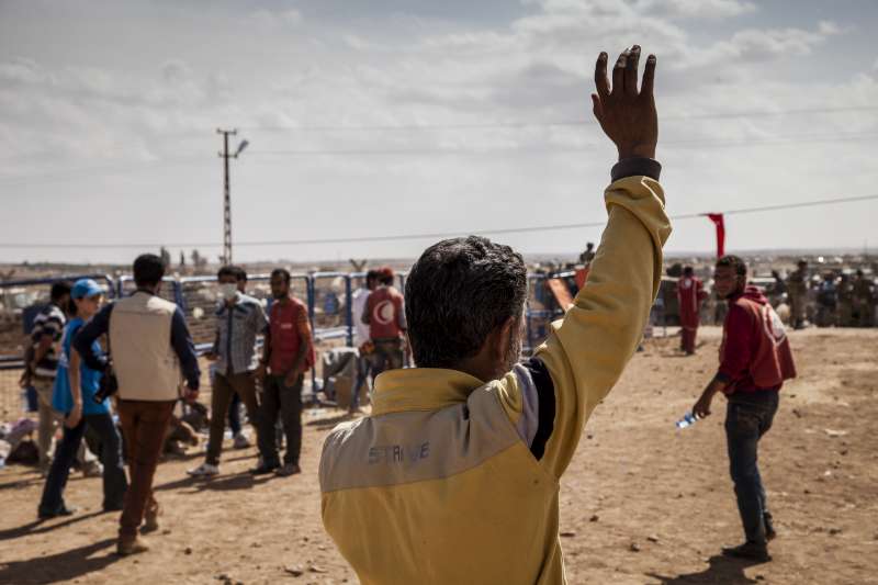 Faysal waves to relatives still waiting to enter Turkey from Syria. © UNHCR/I.Prickett