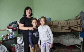 A Ukrainian mother poses with her daughter and a young friend in the room where she lives with her family in a centre for displaced people in Slavyansk. Most of the people are from the Luhansk and Donetsk regions. © UNHCR/E.Ziyatdinova
