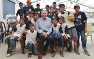 Jacques Rogge, the UN Special Envoy for Youth Refugees and Sport, poses in Azraq camp with some of the young Syrian refugees he encouraged. © IOC/R.Juilliart