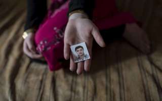 A 14-year-old Syrian refugee in Lebanon holds out a photograph of her fiancé. The marriage was arranged by her parents, but the child was not happy.