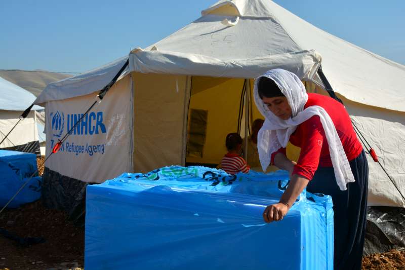 Mother-of-seven Laila opens a box containing insulation packaging that will keep her family warm this winter.