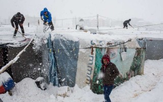 Syrian refugees remove snow from their shelters at an informal tented settlement in the Bekaa Valley, Lebanon during a blizzard earlier today.