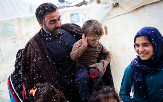 Hassan and his children step outside their shelter in Lebanon