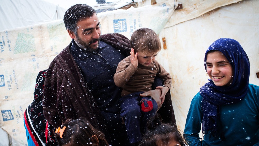 Hassan and his children step outside their shelter in Lebanon