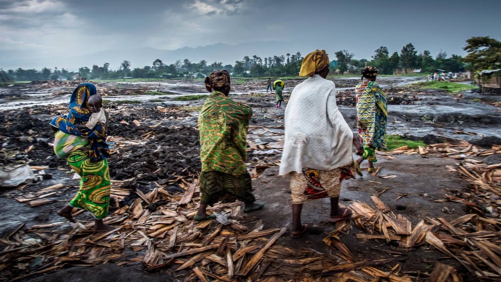 Congolese women return to see what little is left of Kiwanja settlement.