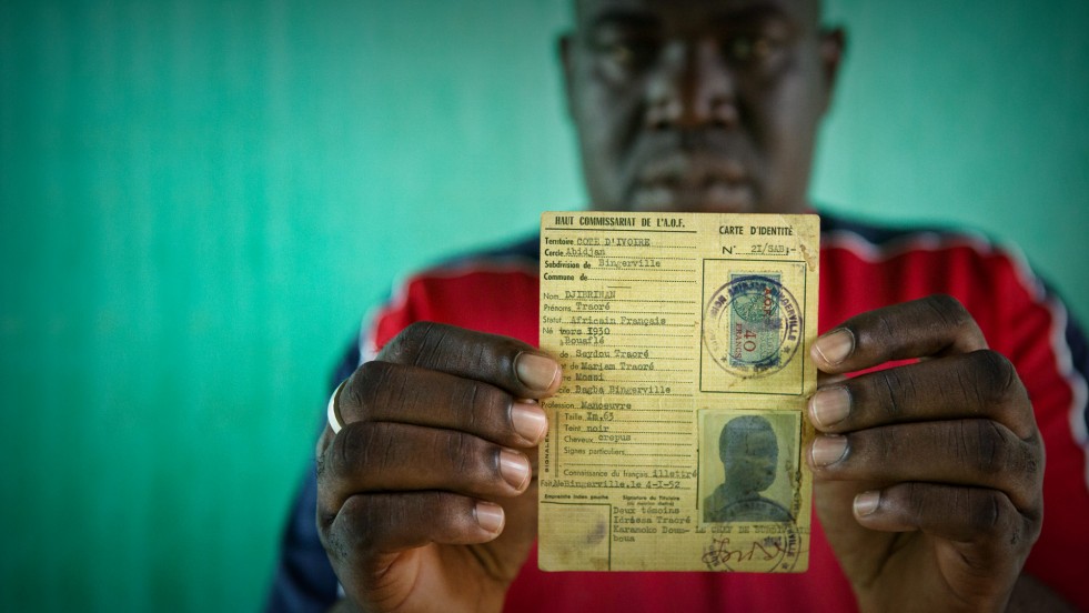 Oumar, who was at risk of statelessness, holds his father’s identity card from French colonial times.