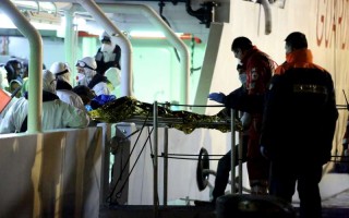 Medics carry a young man on a stretcher off the Italian Coastguard vessel Gregoretti when it reached Palermo in Sicily earlier this week after rescuing people from the Mediterranean.