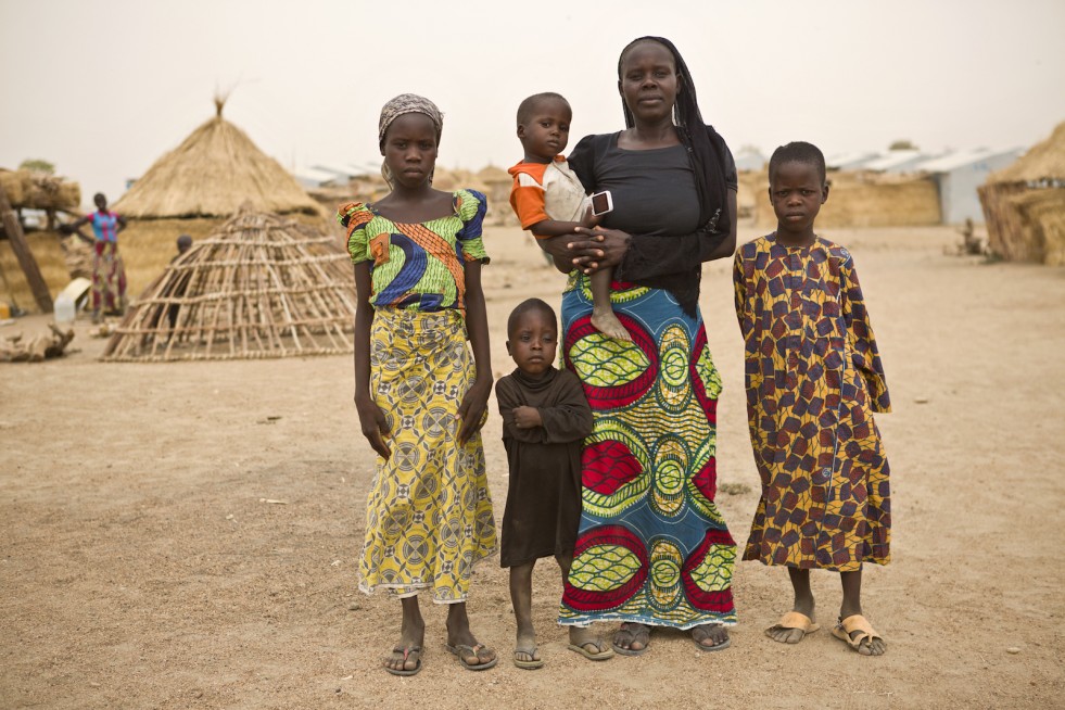Ibrahim (right) stands with his mother and three siblings in Minawao camp, Cameroon. “It is not easy,” his mother says. “The children without a father, fetching water, preparing food. 