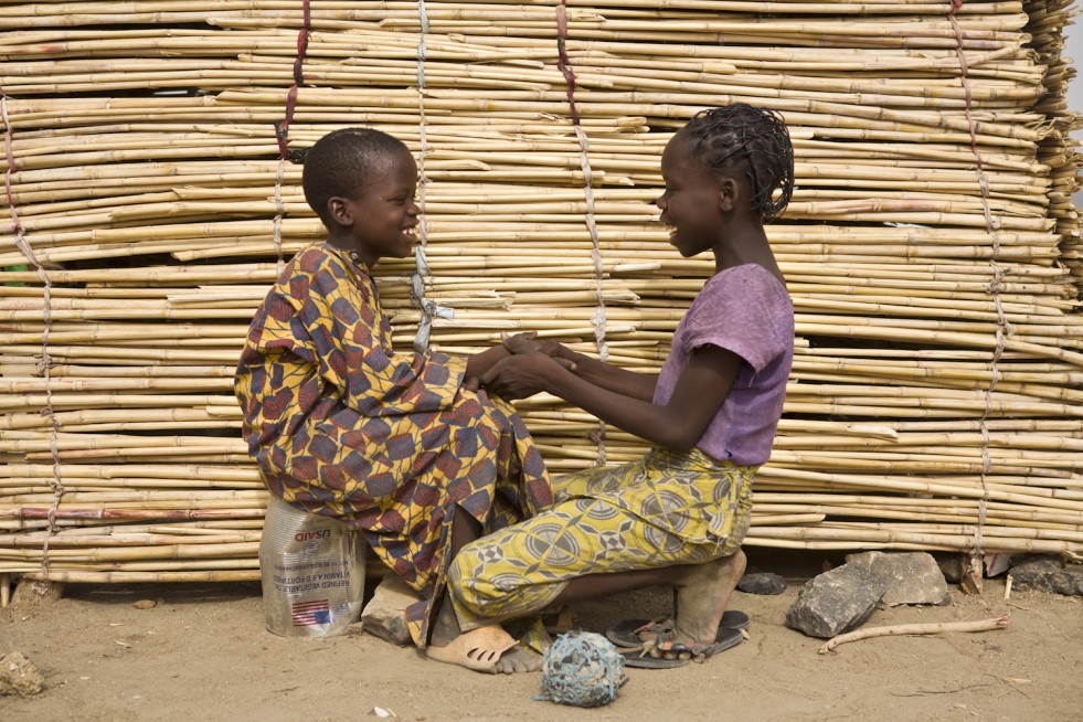 Ibrahim and his sister, Larama, 13, chat in front of their shelter in Minawao camp, Cameroon. “I am the one who unburied him and carried him on my back,” says Larama. 