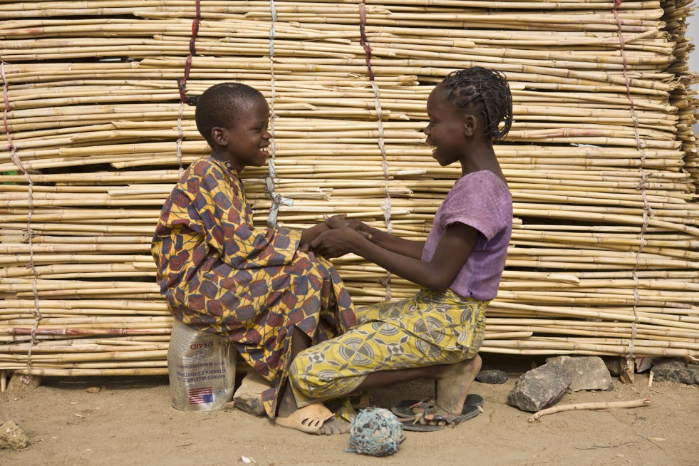 Ibrahim and his sister, Larama, 13, chat in front of their shelter in Minawao camp, Cameroon. “I am the one who unburied him and carried him on my back,” says Larama.