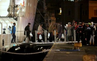Survivors of the deadly shipwreck at the weekend disembark from the Italian Coastguard ship Bruno Gregoretti at Catania in Sicily. More than 800 people are feared dead.