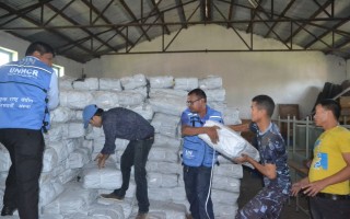 UNHCR staff collect plastic sheeting from a warehouse before it is distributed to people in eastern Nepal affected by the devastating earthquake.