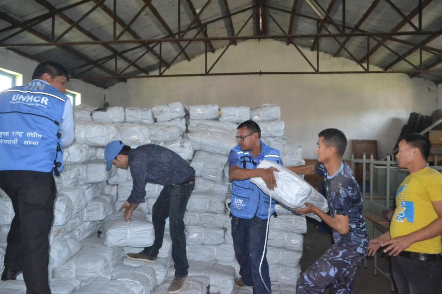 UNHCR staff collect plastic sheeting from a warehouse before it is distributed to people in eastern Nepal affected by the devastating earthquake.