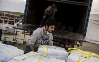 A worker loads UNHCR aid destined for delivery to thousands of people in quake-affected areas of Nepal.