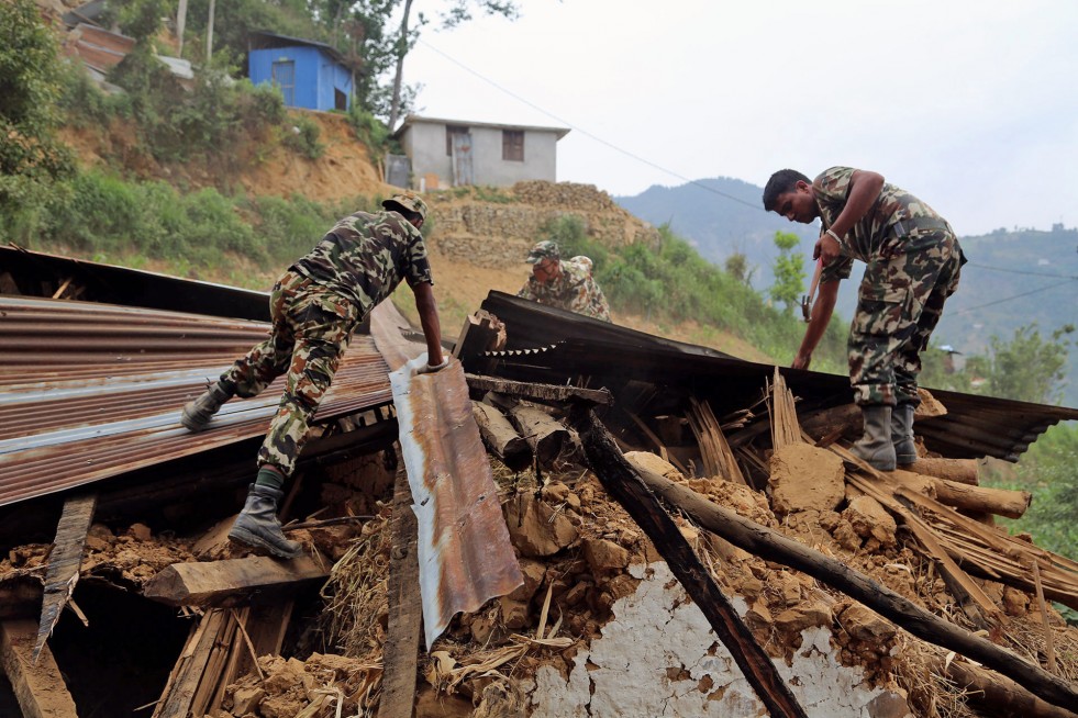 To prevent further injury, Nepali soldiers under the command of Quartermaster Sergeant Besh Bahadur Budhatoki dismantle an earthquake-damaged home in Jhankridanda.