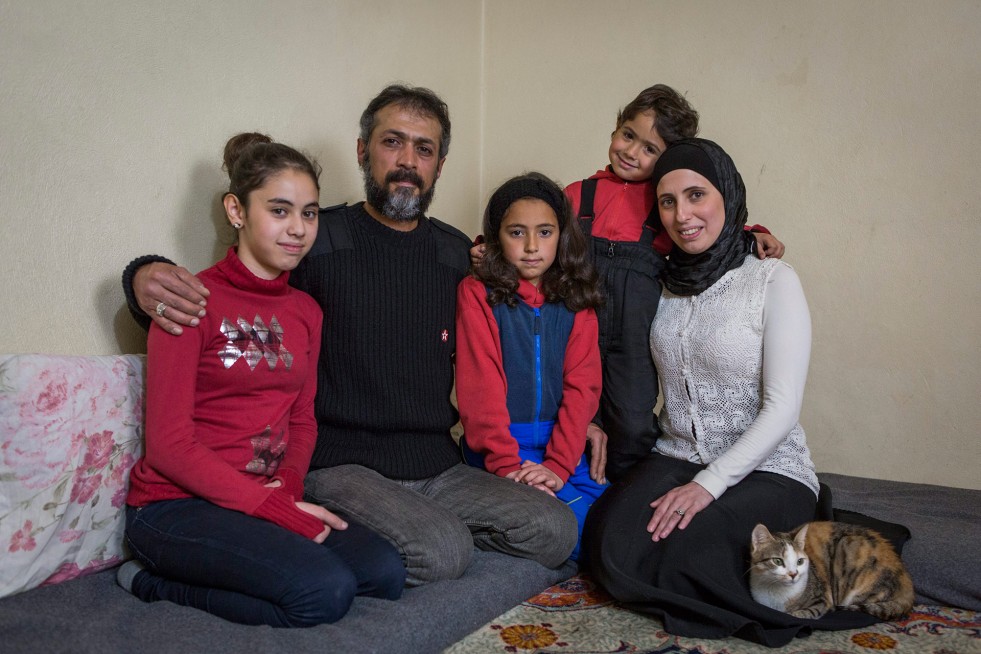 Hassan et Heba posent pour un portait familial avec leurs enfants—Hevy, 14, Asmahan, 9, et Jaafar, 4—dans leur maison au Liban. Ils ont fui la Syrie en 2013.