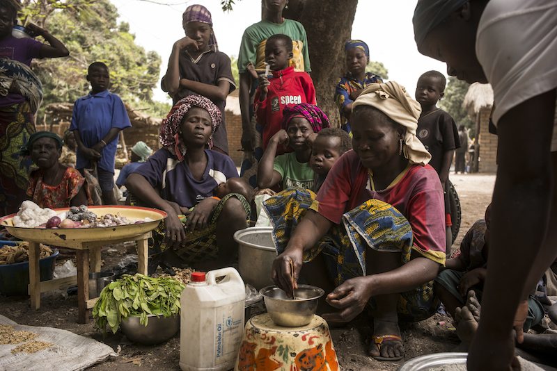 Céline, a 35-year-old refugee from the Central African Republic, sells her homemade oil in Dilingala's marketplace. 