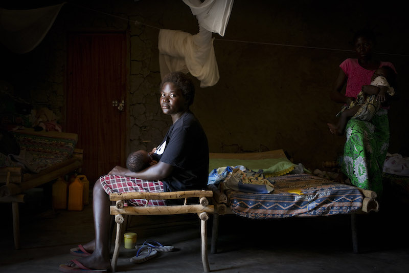 Nema, who was kidnapped by the LRA four years ago, sits on her bed with her baby in the shelter provided by Sister Angélique. 