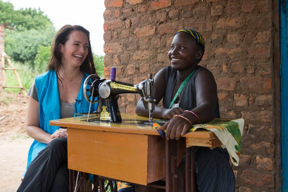UNHCR High Profile Supporter Kristin Davis spends time with Fiona Taba (18) a South Sudanese refugee who's become a tailor and a fashion designer. Fiona also cultivates a plot of land that was donated by the Ugandan Governmnet at the Rhino Base camps settlement.