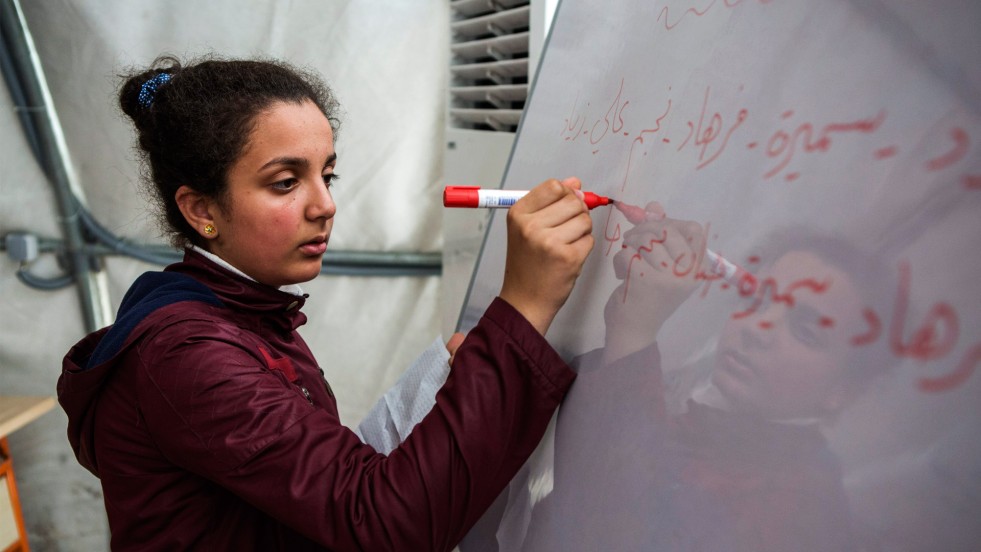 Iva writes the following week's schedule for her classmates at the end of a class in Suruç camp, Turkey.