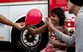 Diana is given a balloon while waiting for medical results at the reception centre in Augusta port, Italy.