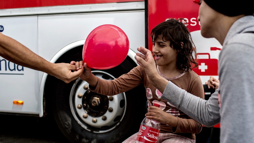 Diana is given a balloon while waiting for medical results at the reception centre in Augusta port, Italy. 