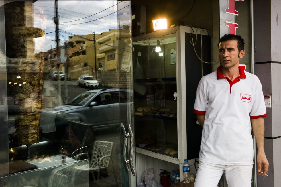 Nasr, who found work at a sandwich shop in Sulaymaniyah after fleeing his home in Syria, takes a break from preparing food.
