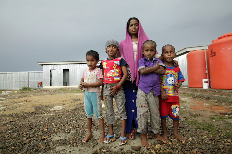 Aisha*, a Rohingya teenager born in a refugee camp in Bangladesh, stands with the four children in a temporary shelter in Aceh, Indonesia, who floated with her from the Bravo to shore in a large cooking pot guided by fellow Rohingya passengers. 