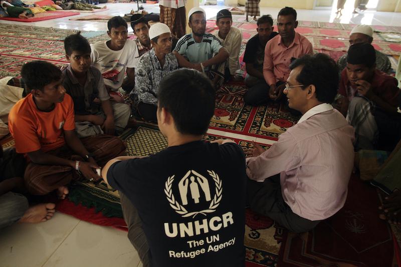 Rohingya men talk to UNHCR staff about their experiences at a temporary shelter in Lhokseumawe, Indonesia. 