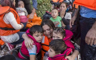 A Syrian woman cries in relief as she embraces her three young children after a very rough crossing of the Aegean from Turkey to the Greek island of Lesbos.