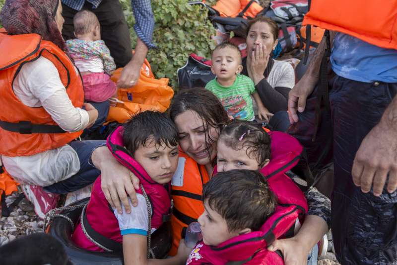 A Syrian woman cries in relief as she embraces her three young children after a very rough crossing of the Aegean from Turkey to the Greek island of Lesbos.