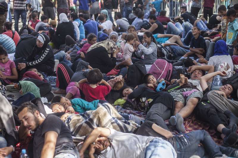 Des personnes se reposent à la gare de Tovarnik en Croatie en attendant de prendre un train pour rejoindre un camp de réfugiés près de Zagreb.