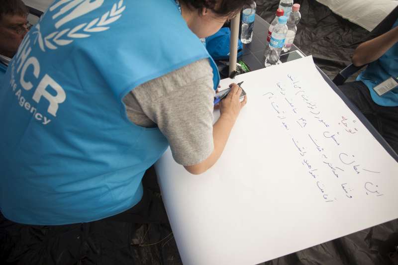 Mandana Amiri, UNHCR protection officer, writes an information poster in Farsi for refugees at the Croatian government transit center in Opatovac, near the Serbian border.