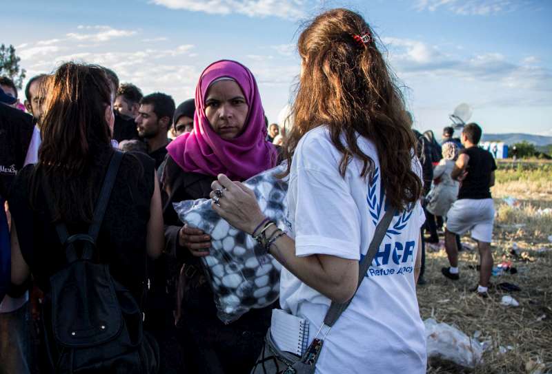 A UNHCR staff member distributes blankets to people waiting to cross the Greek-FYR Macedonian border. UNHCR staff have been at the border since the start of the current crisis, monitoring the situation and helping the vulnerable.