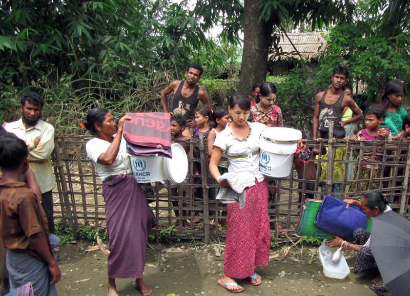 Villagers receive household items from UNHCR in Nyang Pin Gyi village, Rathedaung, Rakhine State, Myanmar, in August 2015. Cyclone Komen swept past western Myanmar causing extensive damage.