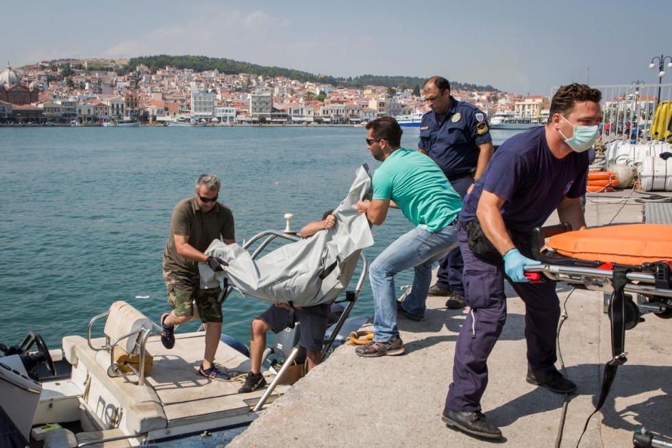 Greek coastguard officials, port police and paramedics lift the body of an unidentified drowning victim after a boat sank near the eastern coast of Lesvos.