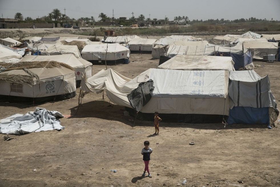 Children stand by their tents in a makeshift camp for internally displaced people who have fled violence in Iraq's Anbar Province and come to Bzeibiz Bridge.