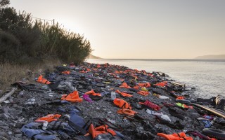 Discarded life jackets and inflatable boats litter a beach on Lesvos.