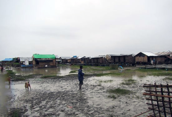 A man stands in a flooded section of Nget Chaung camp for internally displaced people in Pauktaw township, Rakhine State. UNHCR was at Nget Chaung to assess damage and identify needs after Cyclone Komen recently swept through western Myanmar.