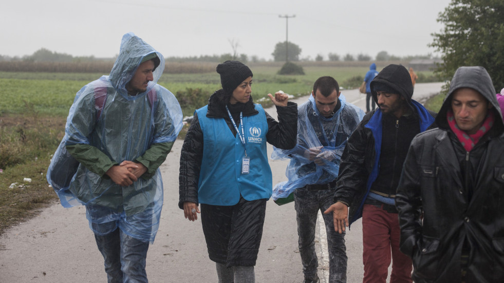 Refugees walk towards a bus during heavy rain at the village of Bapska, Croatia.