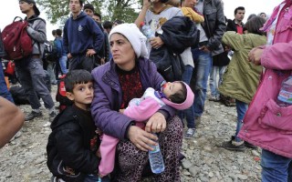 Une mère et ses enfants attendent avec d'autres réfugiés d'entrer au centre de réception de Vinojug à Gevgelija dans l'ex-République yougoslave de Macédoine.