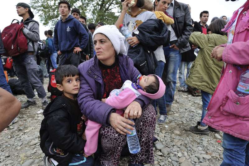 Une mère et ses enfants attendent avec d'autres réfugiés d'entrer au centre de réception de Vinojug à Gevgelija dans l'ex-République yougoslave de Macédoine.