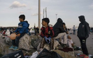 Deux jeunes réfugiés attendent avec leurs parents de se rendre au centre d'hébergement d'urgence de Nickelsdorf, en Autriche, début septembre. L'Autriche fait face à une arrivée sans précédent de réfugiés, principalement depuis la Syrie, l'Iraq et l'Afghanistan.