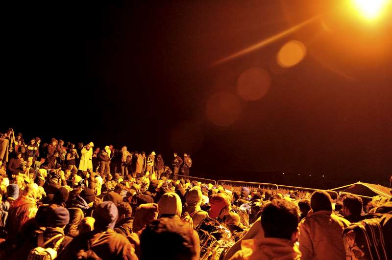 Under the glare of a border light, some 2,000 refugees and migrants at Berkasovo, wait on the Serbian side of the border with Croatia.