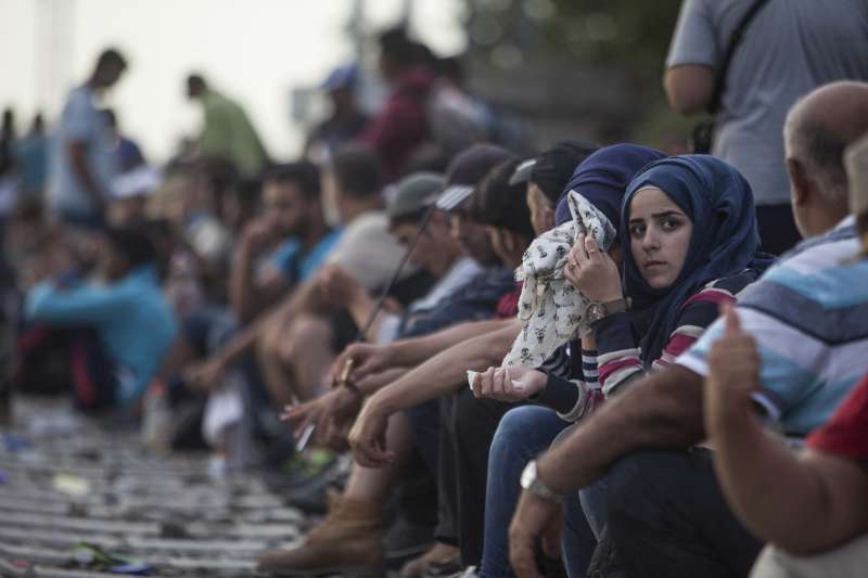 Des jeunes femmes réfugiées attendent un train à la gare de Tovarnik en Croatie.