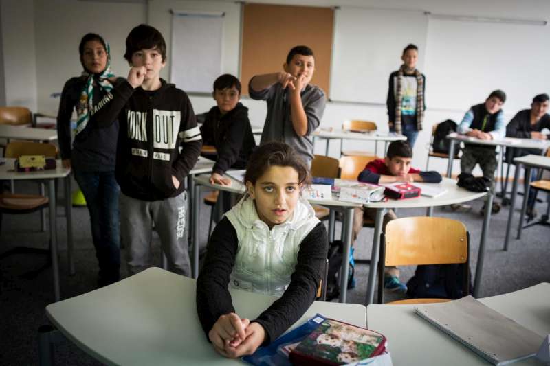 Syrian 12-year old Leen (front) concentrates on the board during a language class 