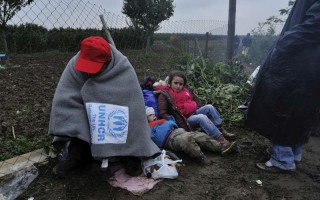 A refugee huddles up against the cold on the border between Serbia and Croatia.